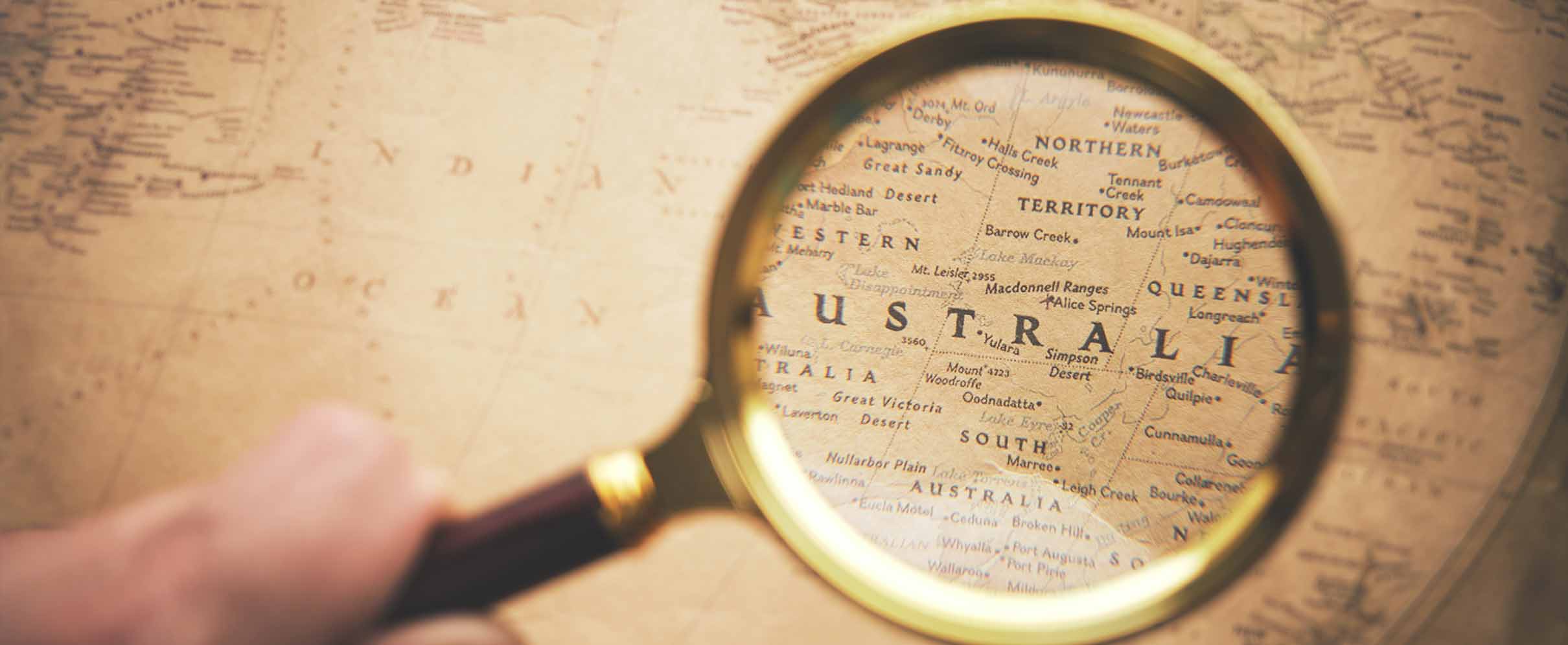 Image of a magnifying glass moving across a map of Australia.